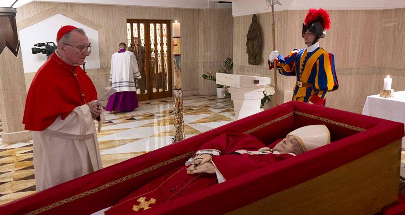 Im roten Gewand mit weißer Bischofsmitra: Der Leichnam von Papst Franziskus, aufgebahrt in einem schlichten Holzsarg in der Kapelle seiner Residenz Santa Marta. Um die gefalteten Hände ist ein Rosenkranz geschlungen