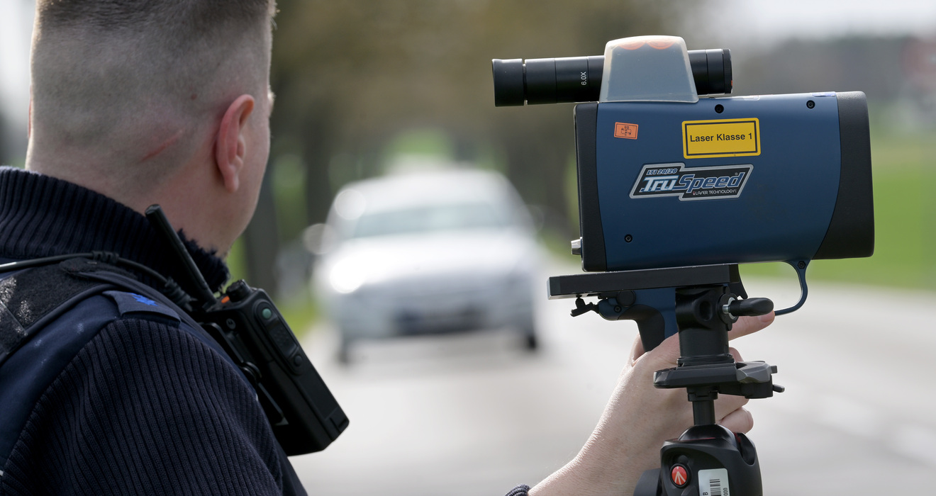 Blitzermarathon-Teilnehmer: Ein Polizist bei der Geschwindigkeitsmessung mit einem Lasermessgerät