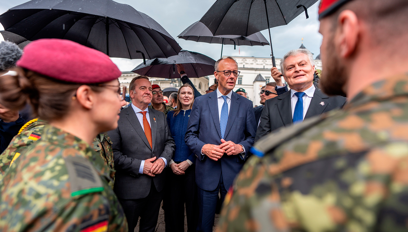 Wollen unbeirrt vom Regenguss die Ostflanke sichern: Pistorius (von li.), Merz, Nauseda